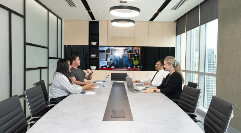 A group of professionals discussing VAT registration steps at a conference table in Dubai, by myOffice