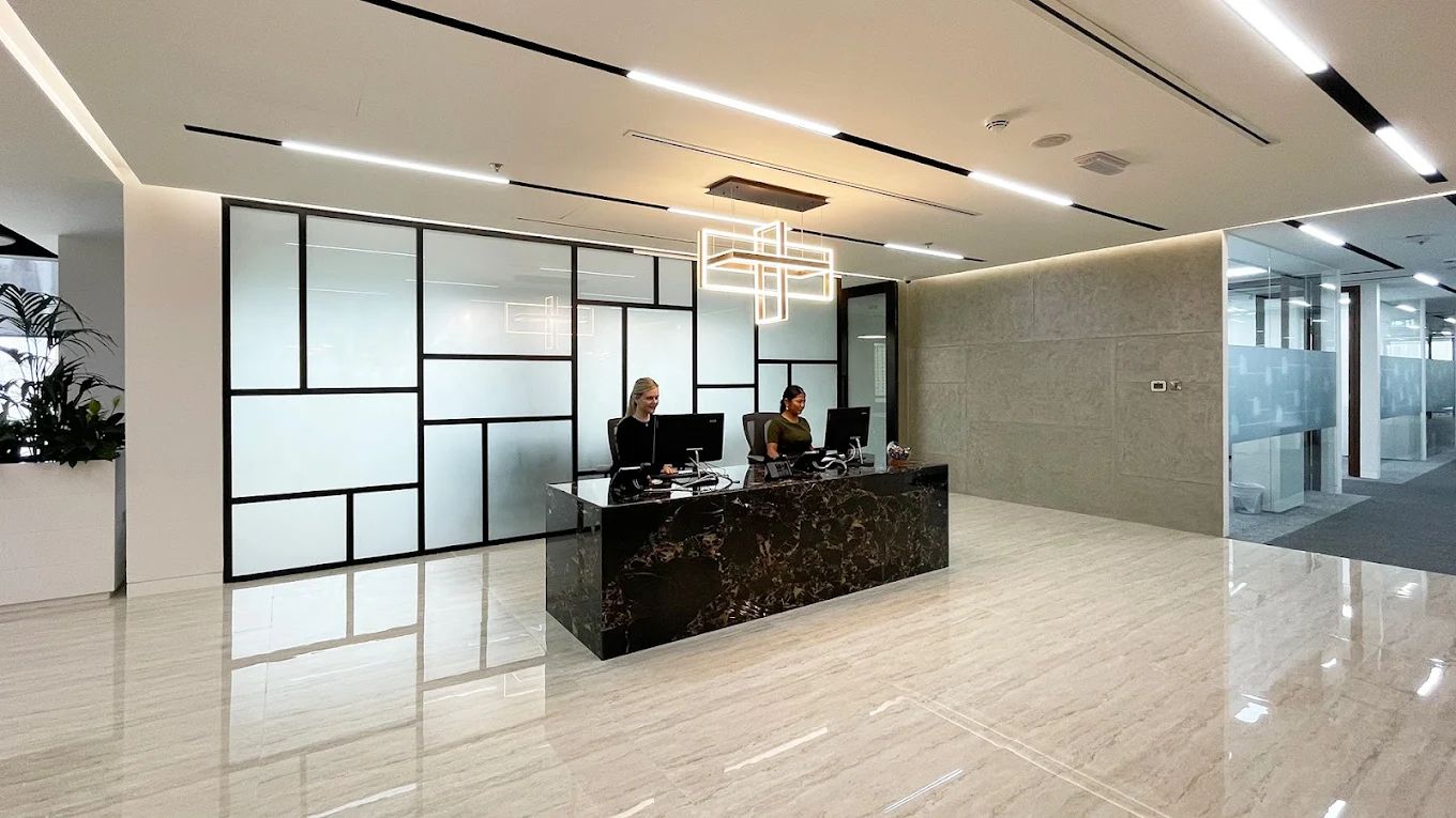 Two women sitting in a concierge area inside a managed office, by myOffice