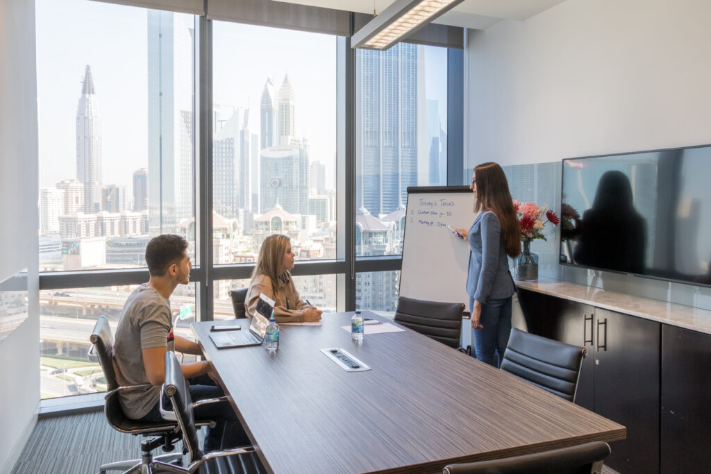 A group of employees having a brainstorming discussion using a whiteboard.