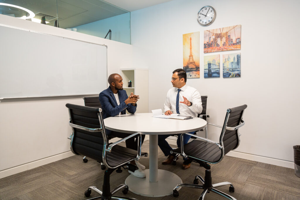 Two employees at myOffice discussing at a round table in myOffice.