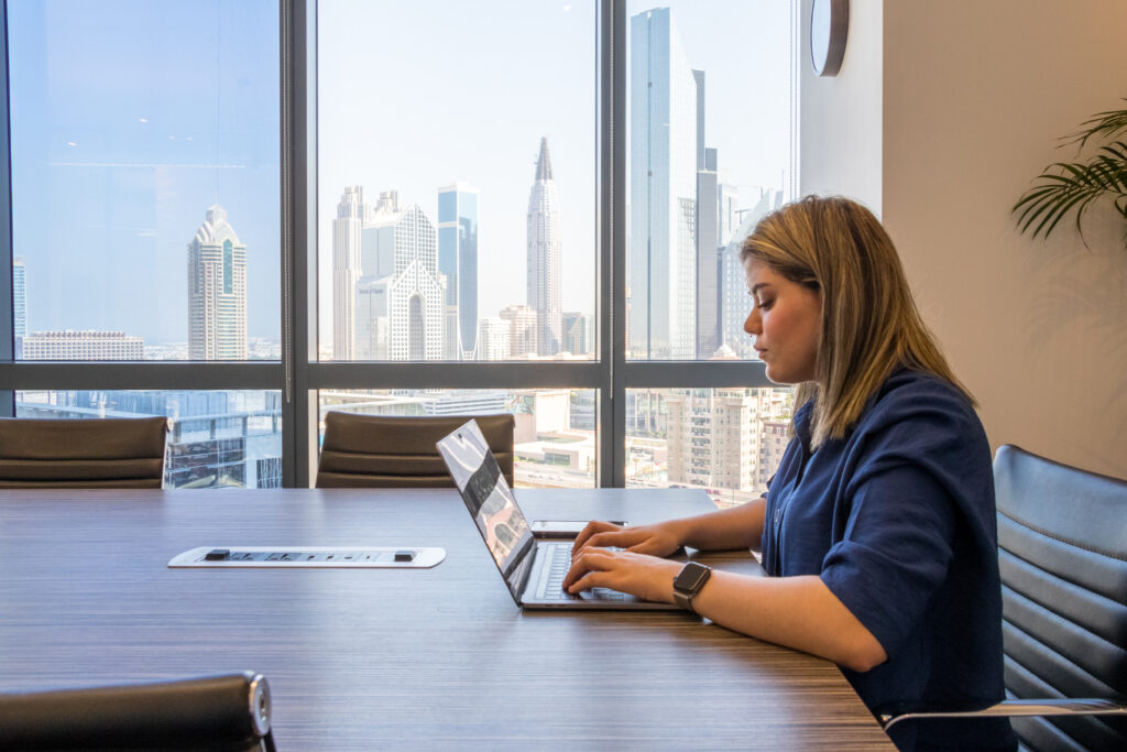 A lady using a laptop in a bright natural light setting